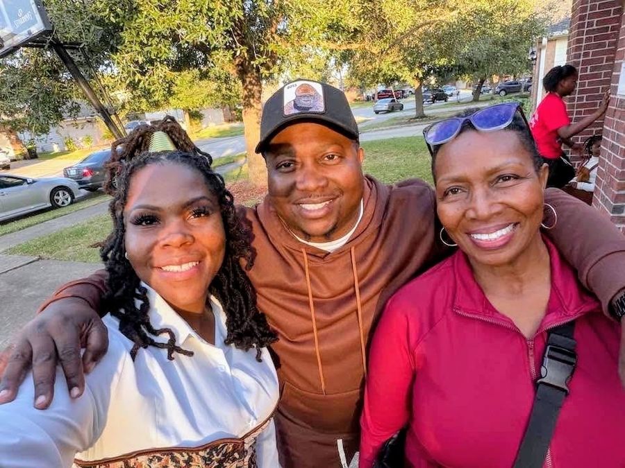 Three people smiling together in an outdoor selfie