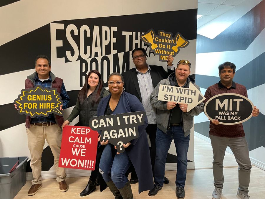 Colleagues posing together with novelty signs at a team event